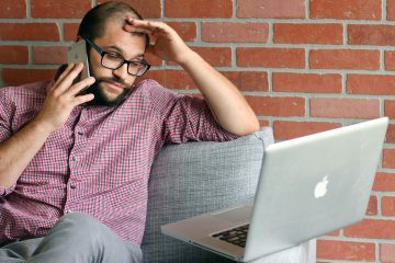 man achter laptop aan het bellen